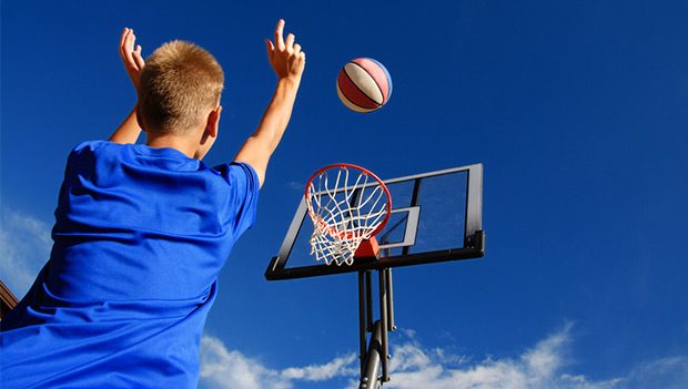 A student taking a shot during outdoor basketball